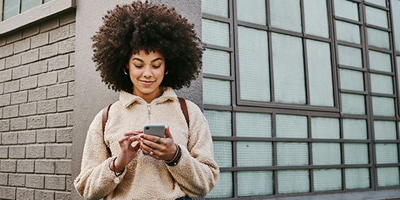 Woman using her cellphone while out in the city.