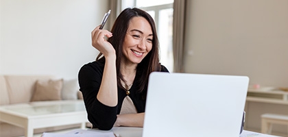 Smiling businesswoman working on laptop.